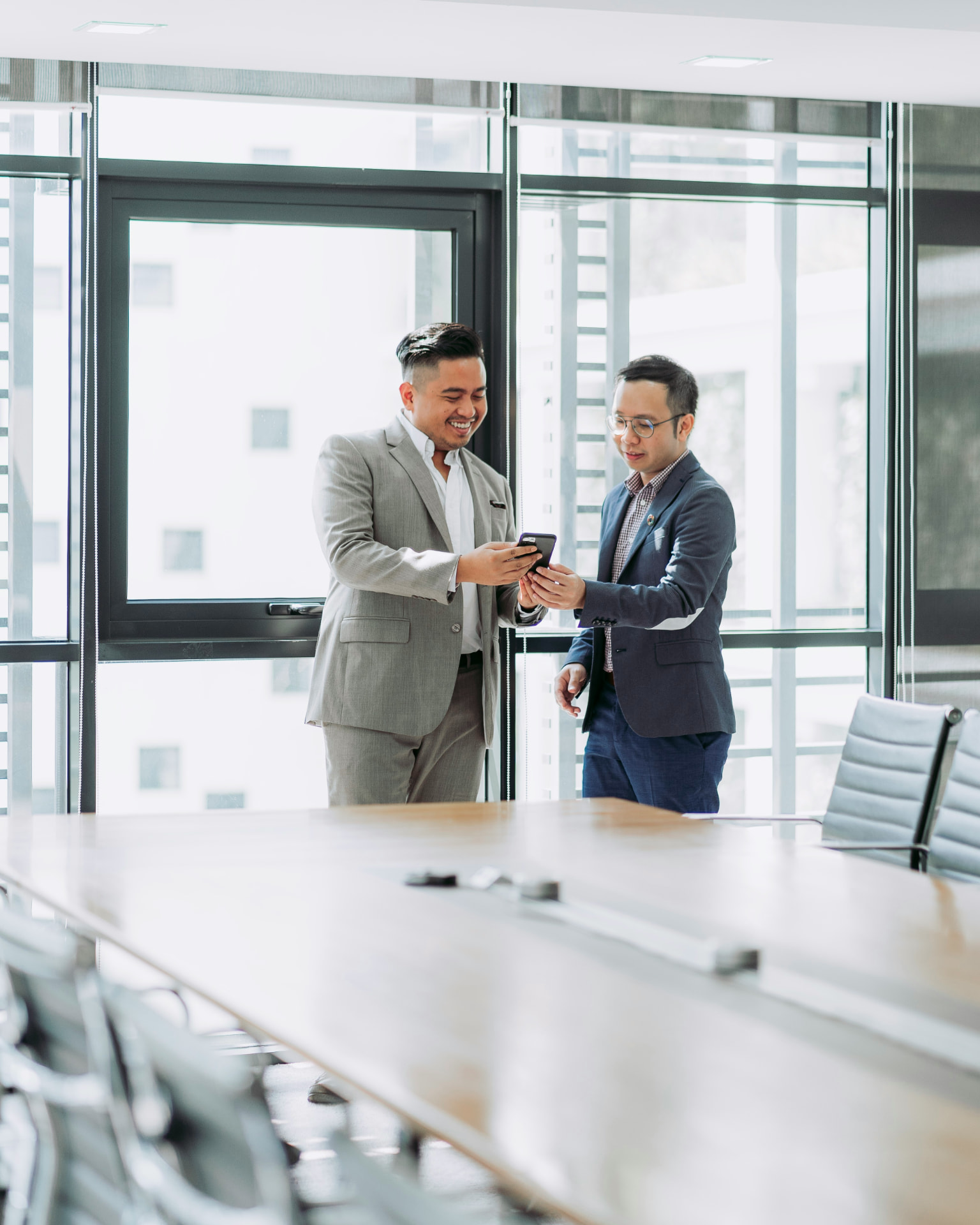 Two professionals sharing ideas in a modern boardroom